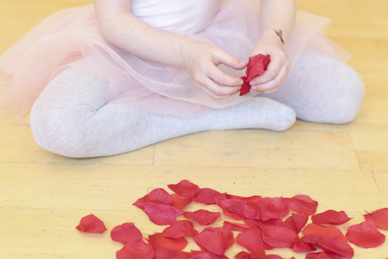 Une danseuse et des pétales de fleurs sur le parquet