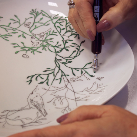 Adhérente peignant une assiette en atelier de peinture sur porcelaine