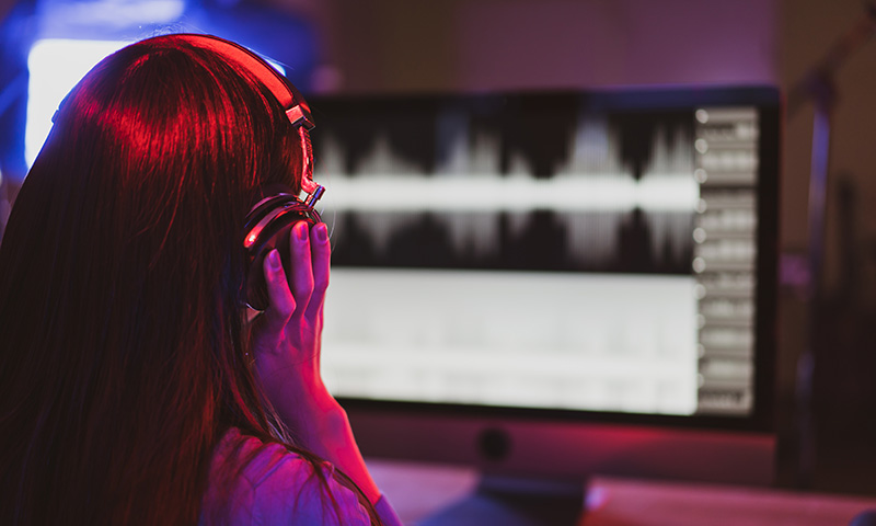 Jeune en train de faire de la musique assistée par ordinateur