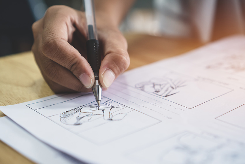 La main d'un jeune homme dessinant une bande dessinée ou un manga