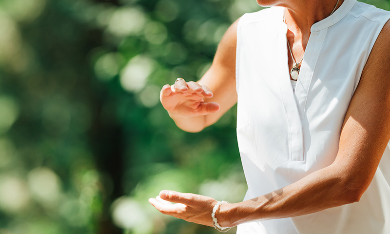Femme pratiquant le qi gong en extérieur